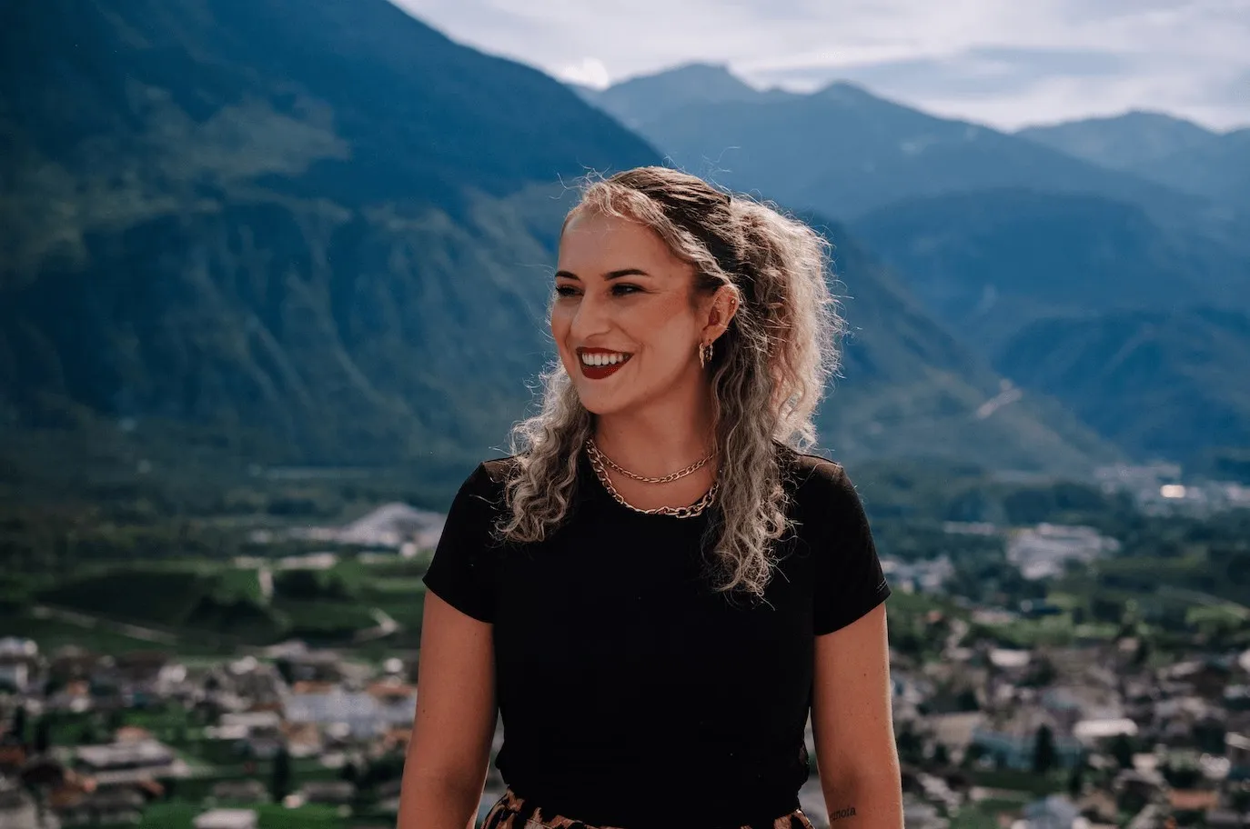 Alisha Cina im schwarzen Shirt, lächelnd vor dem Rhonetal